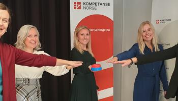 Fem kvinner strekker ut hånda for å trykke på knapp.