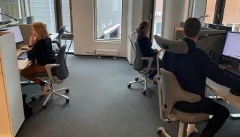 Tre karriereveiledere sitter ved skrivebordet sitt og jobber.
