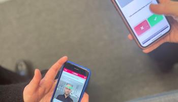Bilde av to mobiler med hender, på skjermen vises spillet GodKollega