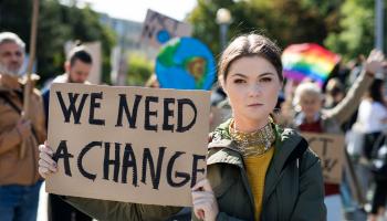 Bilde av ungdom med plakat med teksten "We need a change"