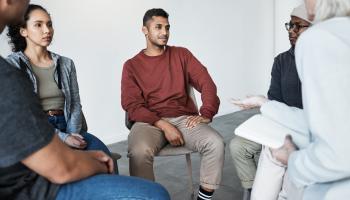 Personer som sitter i en ring og snakker sammen