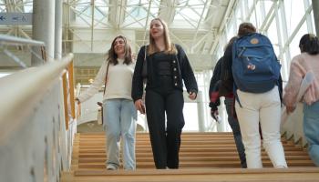 Bilde av smilende studenter i ei trapp på Universitetet i Innlandets avdeling på Lillehammer.