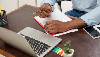 Bilde av laptop og en persons hender