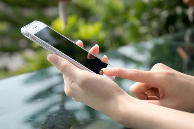 Nærbilde av hender og mobiltelefon