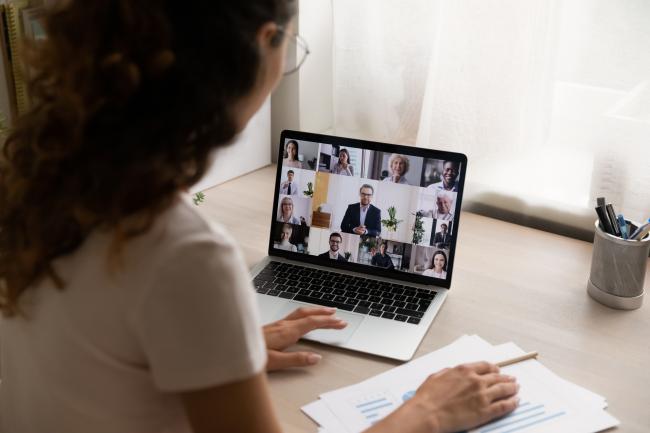 Kvinne sitter i digitalt møte på pc. 