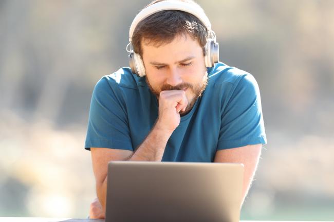 Bilde av ung mann som ser konsentrert på en pc-skjerm